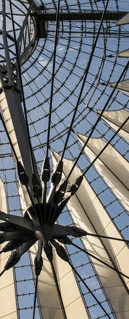 Upward view of a large glass and steel dome structure in Berlin with white fabric panels stretched across it. Upward view of a large glass and steel dome structure in Berlin with white fabric panels stretched across it.